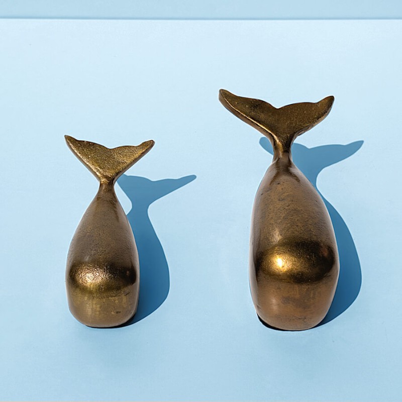 Vue de face des deux baleines dorées sur fond bleu, illustrant parfaitement leur design épuré.