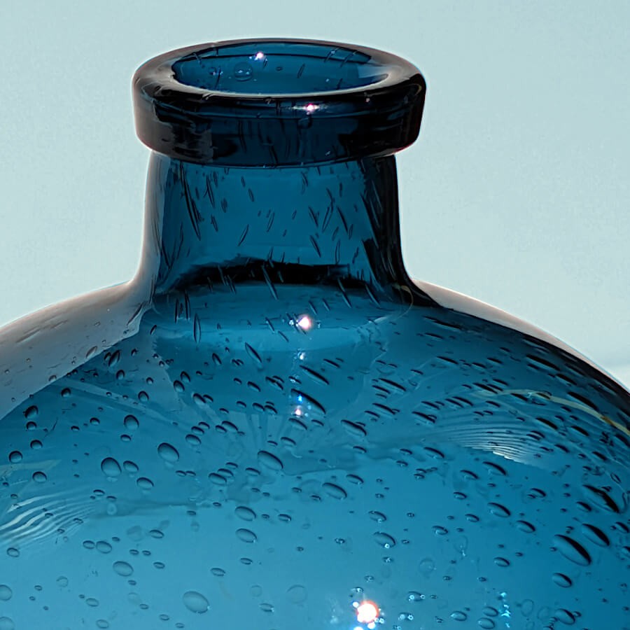 Détail du col étroit et de la transparence cristalline du verre bleu.