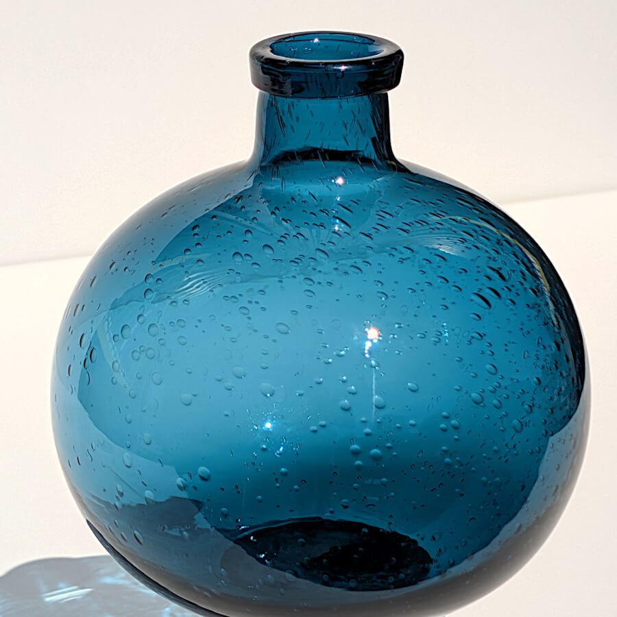 Jeu de reflets et de lumière à travers le verre bullé bleu azur.