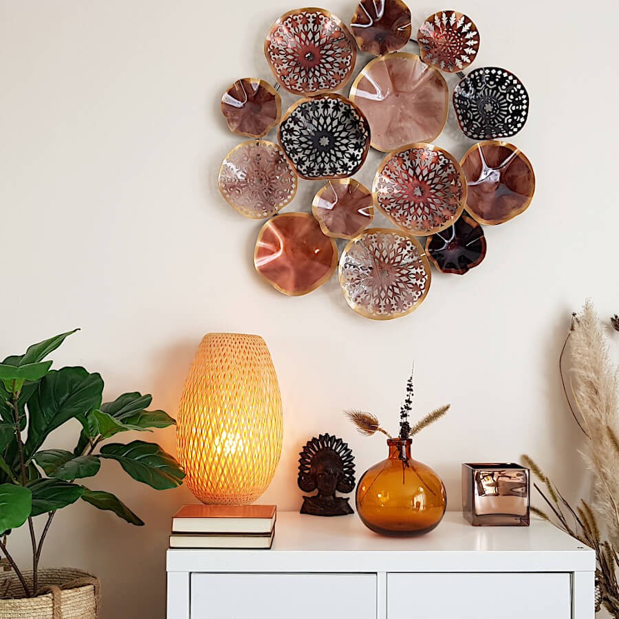 Le vase en verre avec bulles transparentes parmi des décorations aux teintes rouille (décoration murale, lampe).