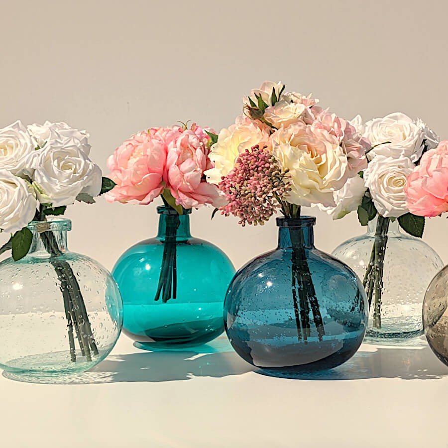 Le vase en verre bullé turquoise parmi d'autres teintes de vases en verre bullé, apportant de la sérénité à la déco.