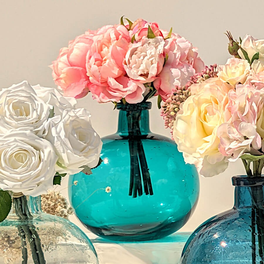 Le vase en verre bullé turquoise rempli de belles roses artificielles : une décoration de mariage parfaite !