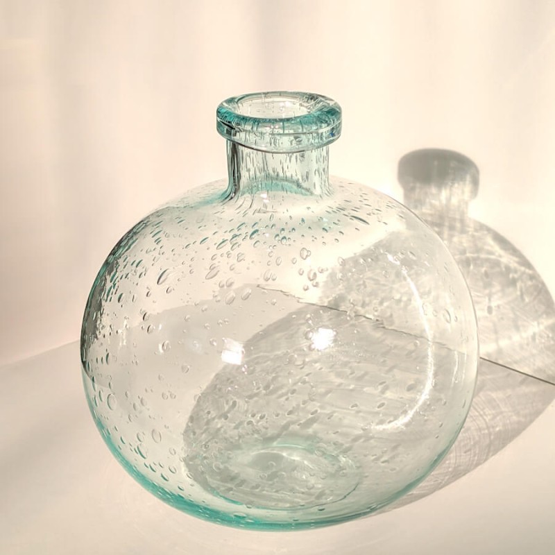 Le vase capturant la lumière, soulignant ses reflets cristallins et bleutés.