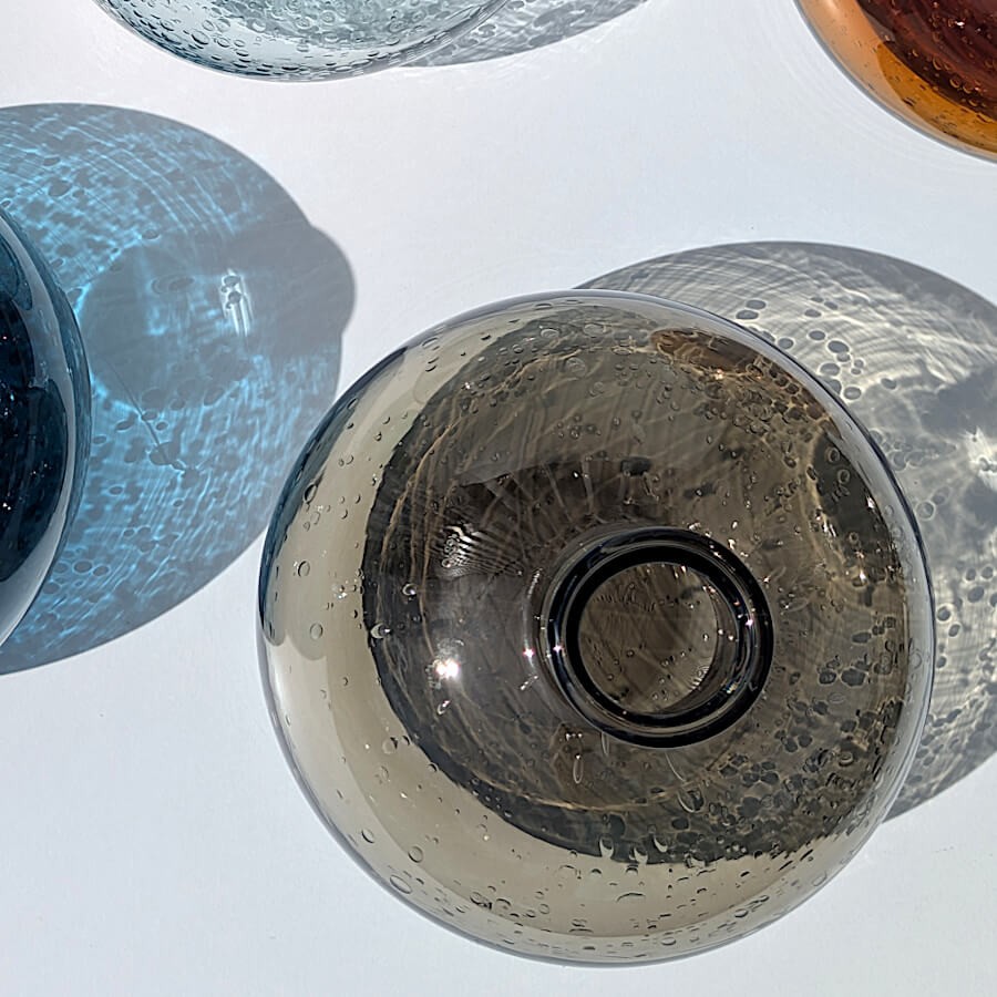 Vue de dessus du vase en verre bullé marron, montrant le jeu d'ombre et de lumière, au soleil.