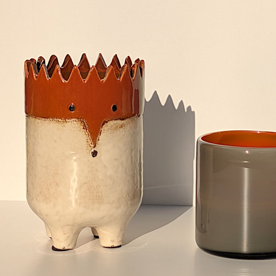 Lumière naturelle sur le cache-pot hérisson, au côté du photophore gris et orange.