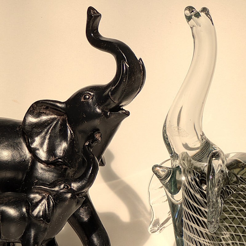 Détail du face-à-face entre l'éléphant noir et la stutuette sulfure éléphant en verre transparent.