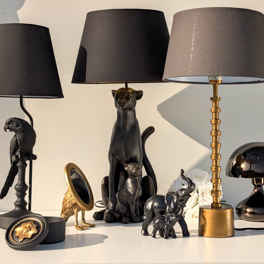 Vue d'ensemble d'une collection animalière chic avec lampes noires et dorées représentant des animaux exotiques.