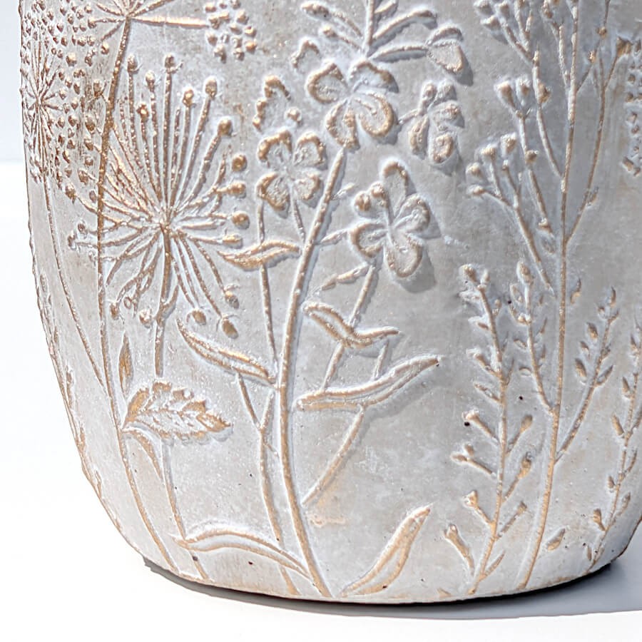 Zoom macro sur la paroi : détails des fleurs sauvages sculptées et rehauts dorés.