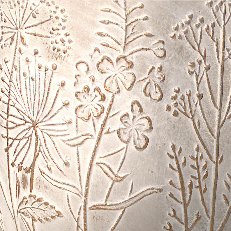 Détail de texture : Gros plan sur le relief des motifs floraux et le grain minéral du ciment.