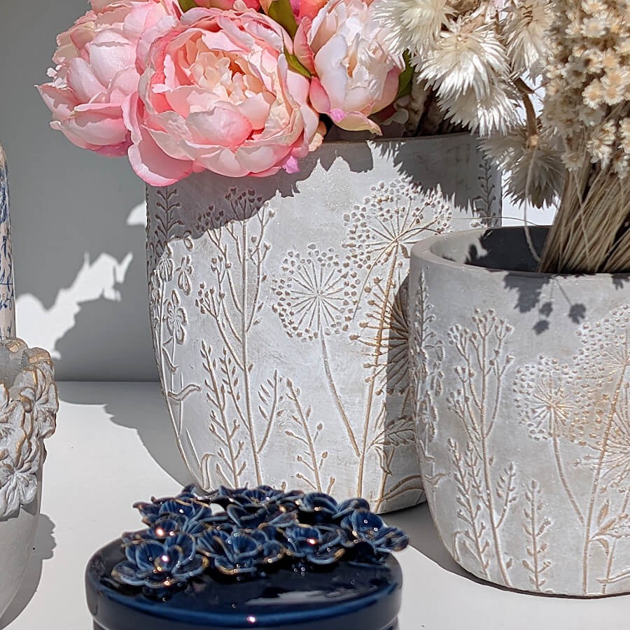 Ambiance printanière : Le cache-pot garni d'un bouquet généreux de pivoines roses.