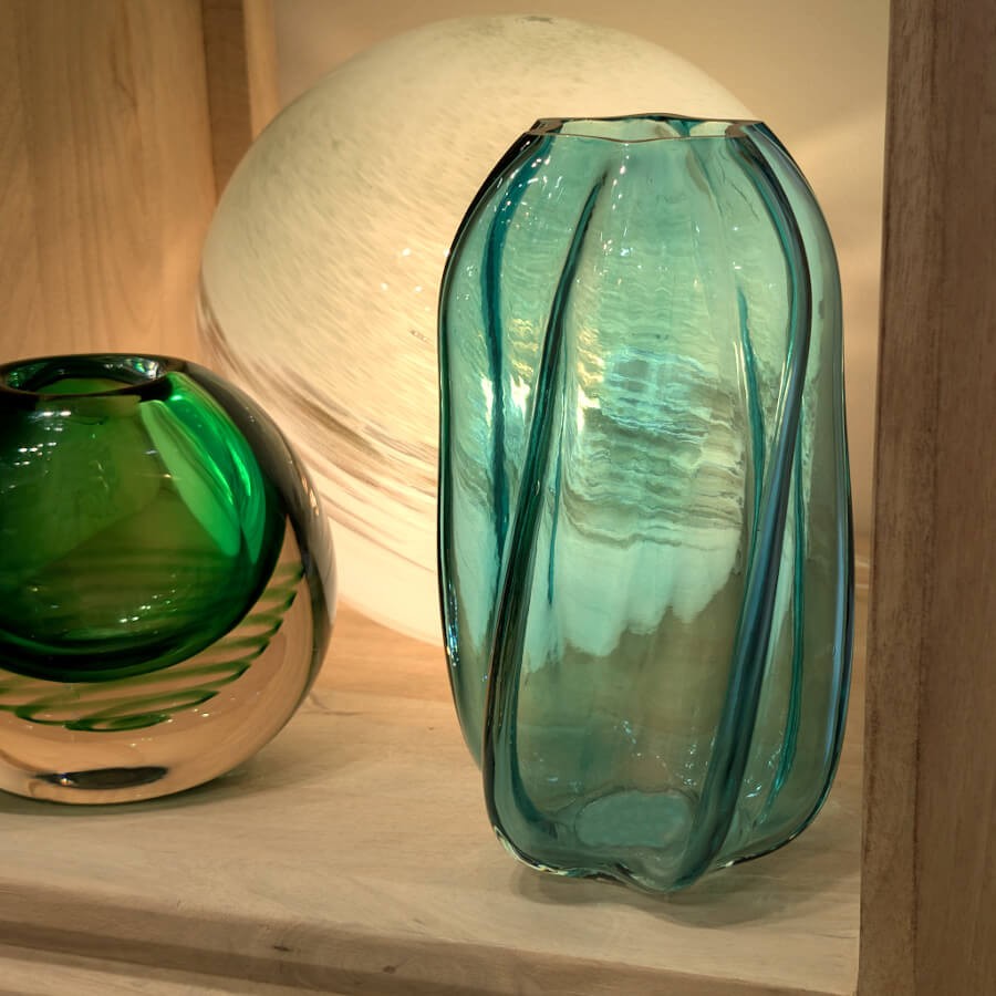 Le vase posé sur un rebord de fenêtre, traversé par les rayons du soleil qui projettent des ombres bleutées.