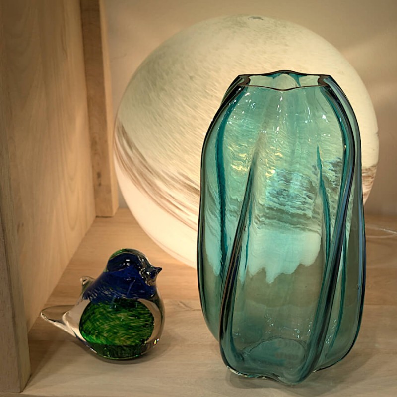 Le vase éclairé par une lampe à poser à côté du sulfure oiseau Deco-Delight, pour une ambiance sereine.