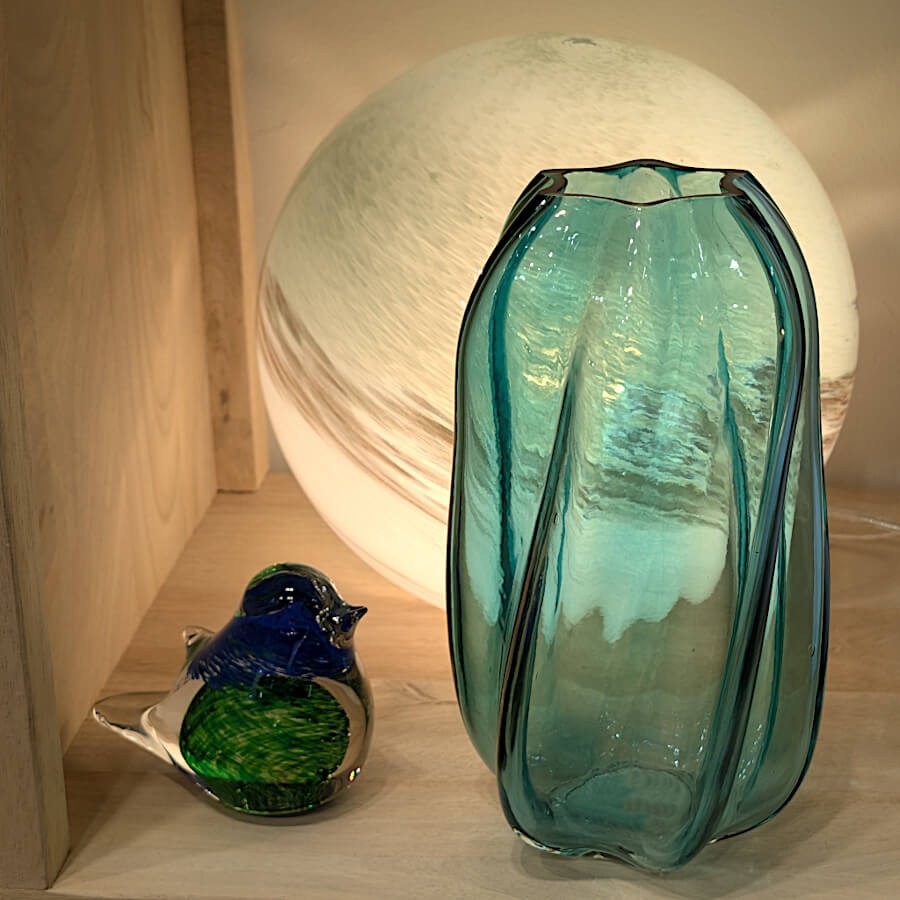 Le vase éclairé par une lampe à poser à côté du sulfure oiseau Deco-Delight, pour une ambiance sereine.
