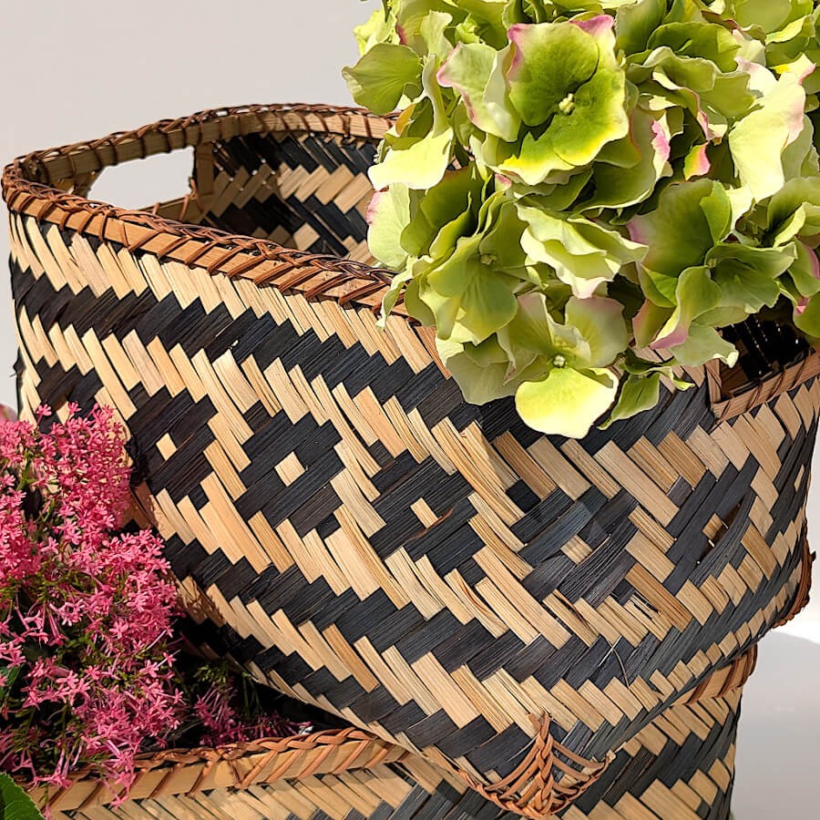 Vue rapprochée sur le flanc du panier mettant en valeur la précision du tressage croisé noir et beige.