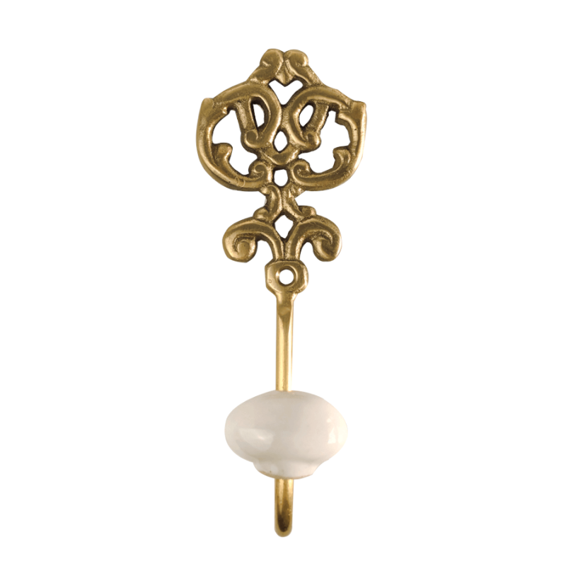 Patère murale en métal doré au style rétro avec arabesques et une boule d'accroche en céramique blanche, sur fond blanc.