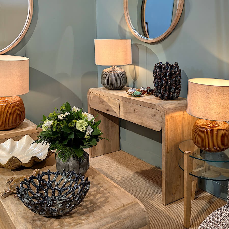 Perspective d'un salon décoré montrant deux lampes de la collection encadrant une console en bois.