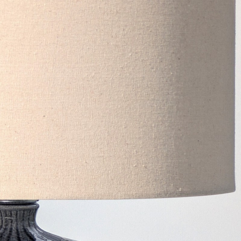 Gros plan sur le grain naturel et la couleur crème du tissu de l'abat-jour (lin).