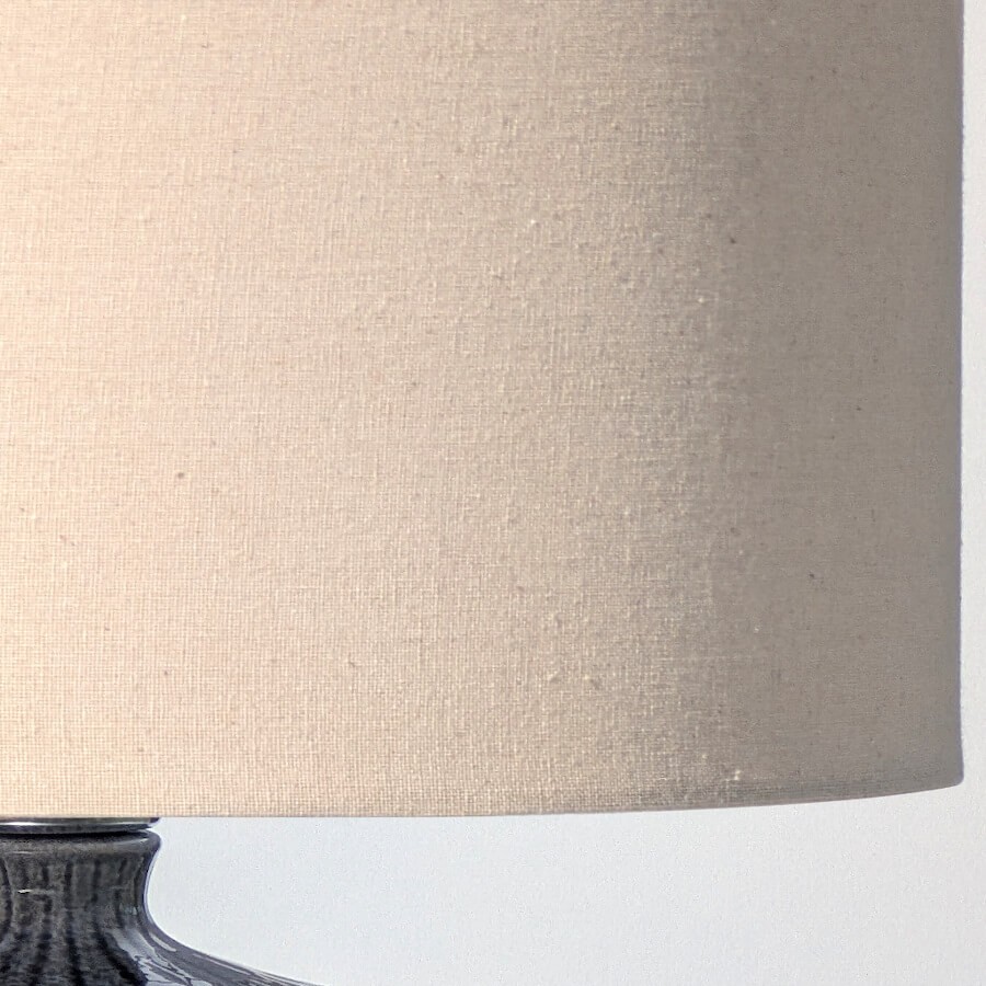 Gros plan sur le grain naturel et la couleur crème du tissu de l'abat-jour (lin).