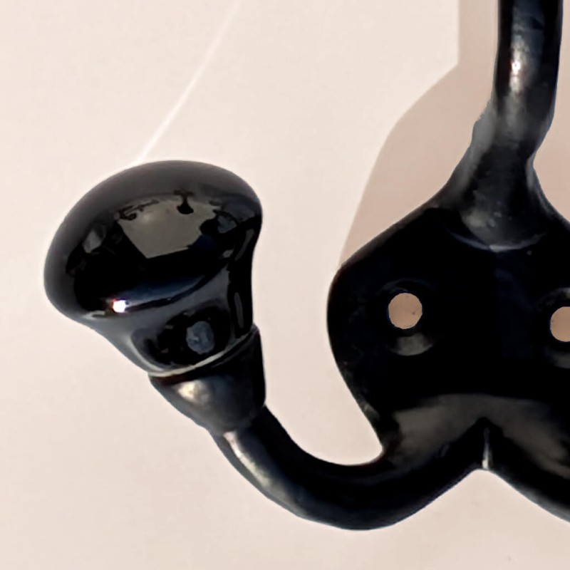 Zoom finition : Éclat brillant de la boule en céramique noire et détail du bras en métal.