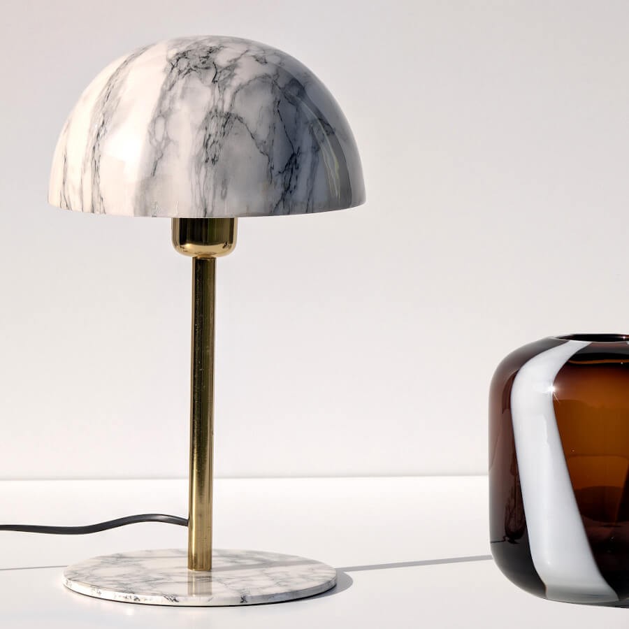 Vue de trois-quarts : Lampe en marbre blanc avec socle rond et tige en laiton doré.