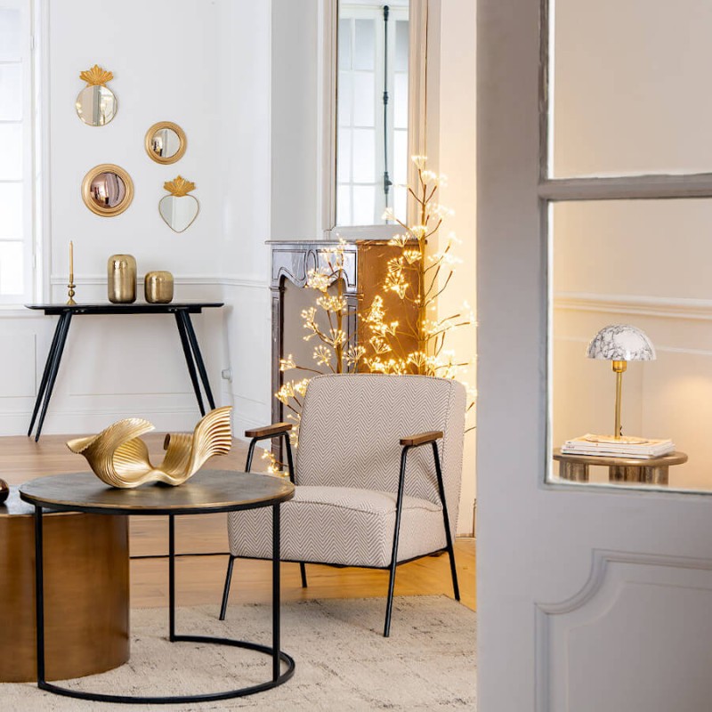 Mise en scène : Lampe en marbre blanc posée sur un bout de canapé dans un salon chic.