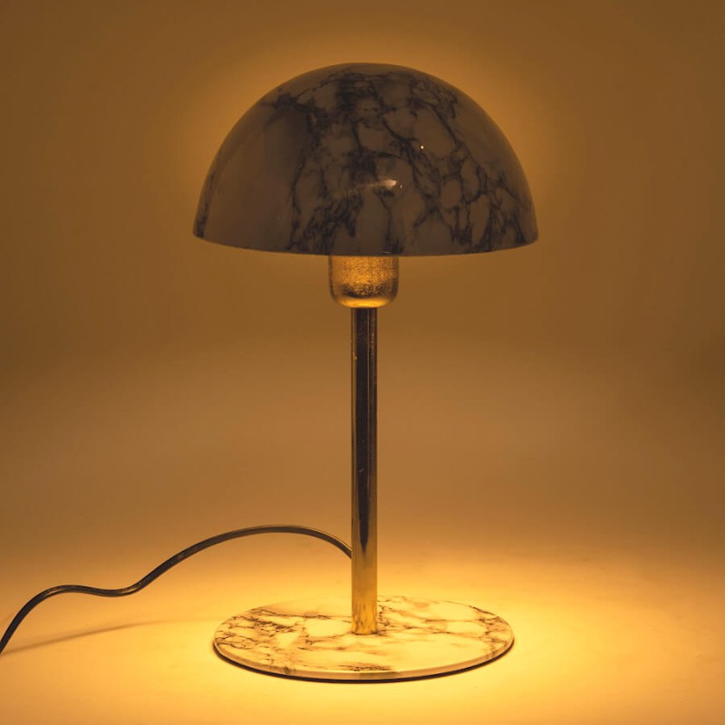 Vue allumée : Lampe champignon en marbre diffusant une lumière chaude et tamisée.
