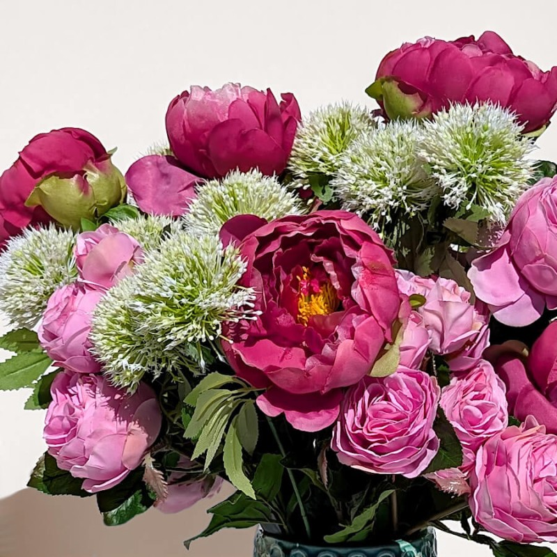 Harmonie florale : Composition de pivoines roses et fuchsia avec des allium nigrum blanches.