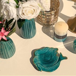 Coupelle sirène turquoise disposée sur une table près de roses blanches et de la bougie Nuances aquatiques Deco-Delight.