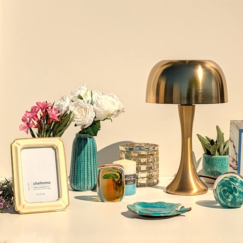 Ambiance Riviera Dorée : la coupelle décorative sirène à côté d'une lampe champignon dorée et d'un cadre photo crème.