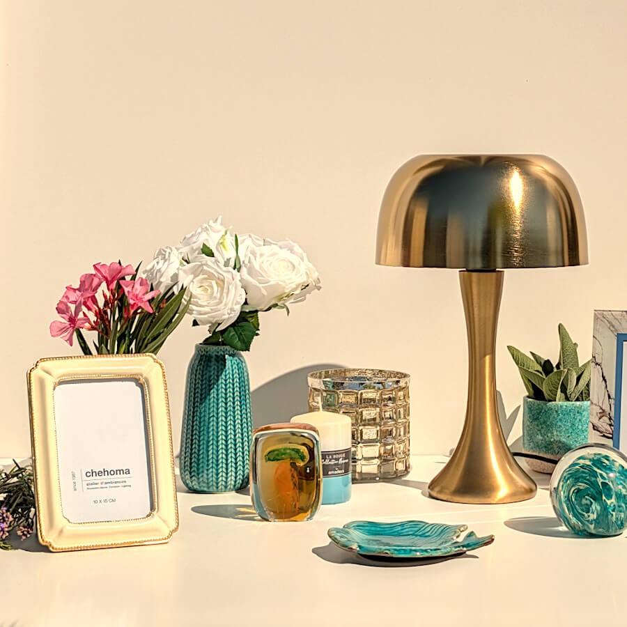 Ambiance Riviera Dorée : la coupelle décorative sirène à côté d'une lampe champignon dorée et d'un cadre photo crème.