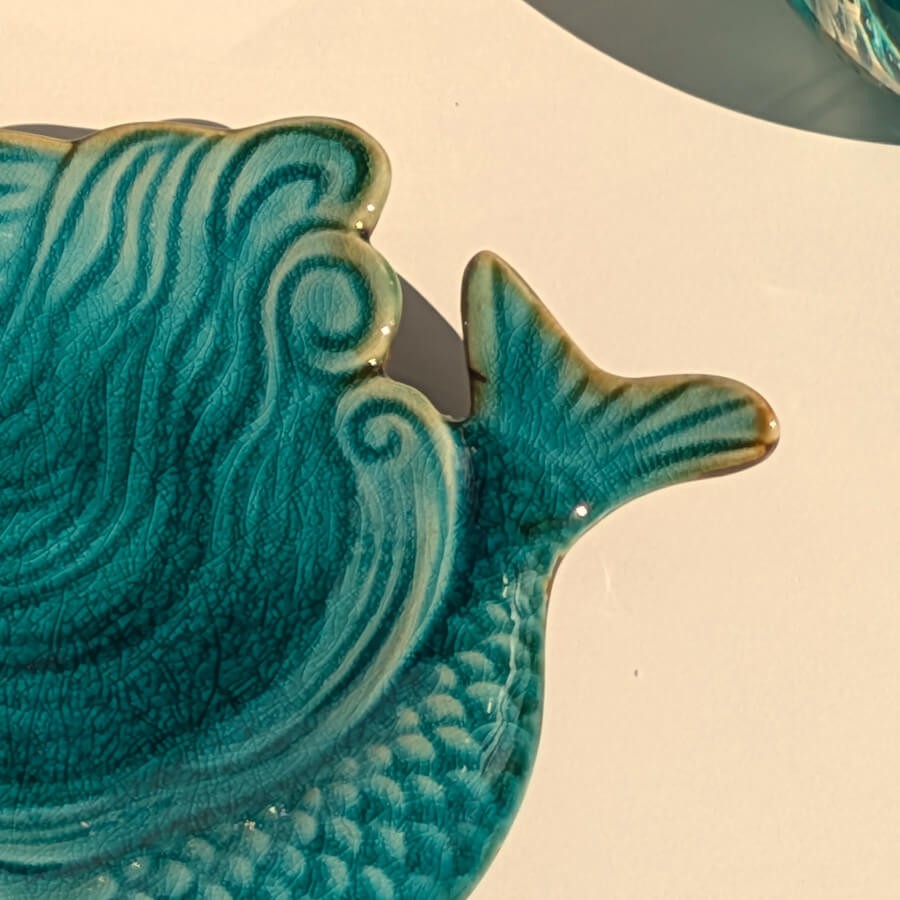 Zoom motif : Détail de la nageoire caudale sculptée et recouverte d'un émail turquoise éclatant.