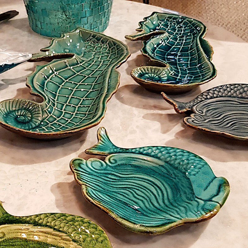 Gamme de céramiques : Assiette sirène présentée aux côtés de coupelles en forme d'hippocampe et de feuille.