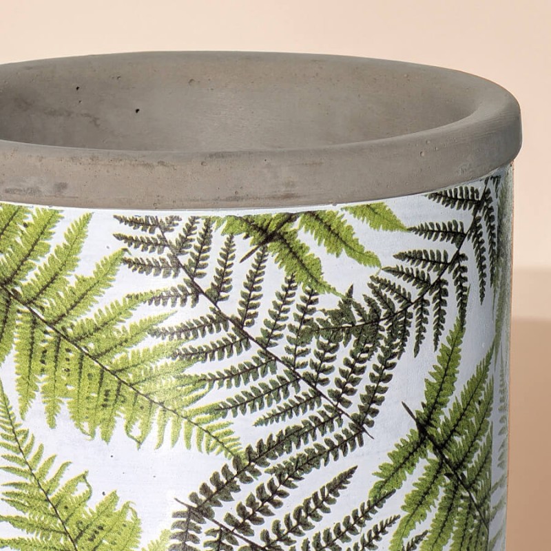Gros plan texture haute : Zoom sur le col brut en ciment gris et le motif de fougère.