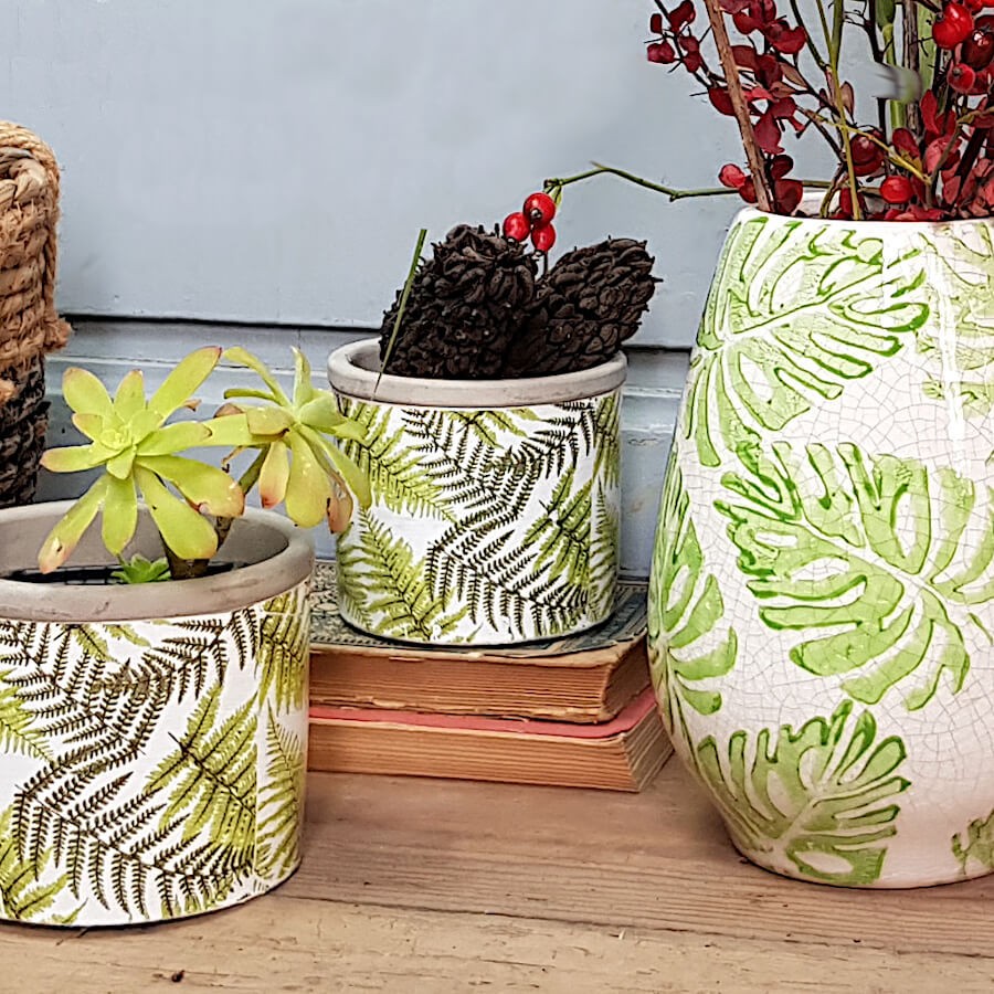 Décoration rustique : Petit pot fougère disposé à côté du vase en faïence aux motifs Monstera de Deco-Delight.
