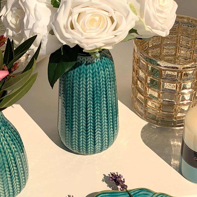 Mise en scène lumineuse : Vase épi turquoise sur table ensoleillée près d'un photophore en verre Deco-Delight.