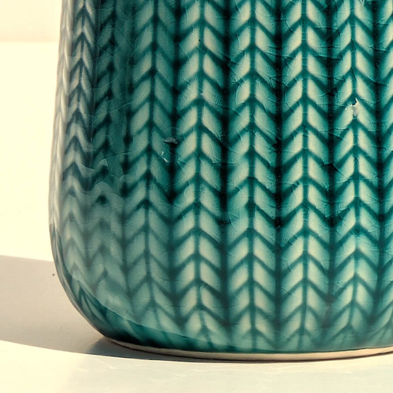 Zoom texture : Gros plan sur les détails sculptés en épi et l'émail turquoise brillant.