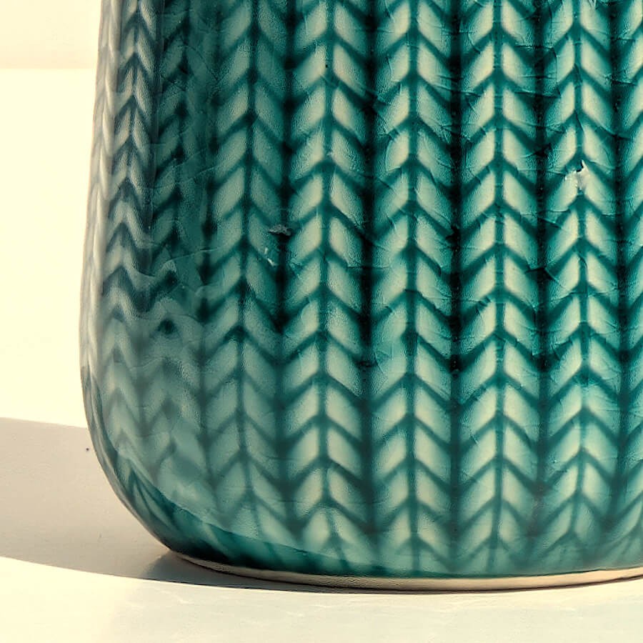 Zoom texture : Gros plan sur les détails sculptés en épi et l'émail turquoise brillant.