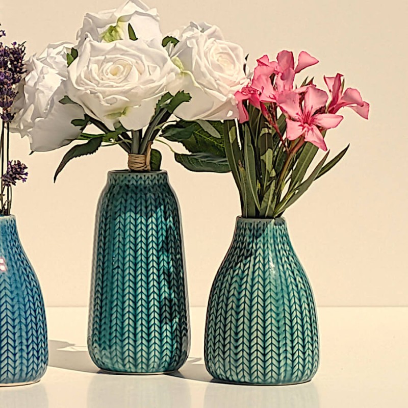 Duo de fleurs : Vases épi bleu et turquoise garnis de fleurs blanches et fushia.