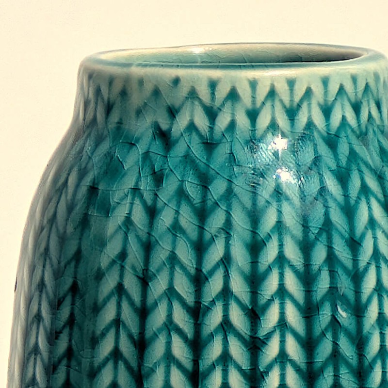 Macro émaillage : Détail resserré sur les reliefs graphiques et les nuances de l'émail turquoise.