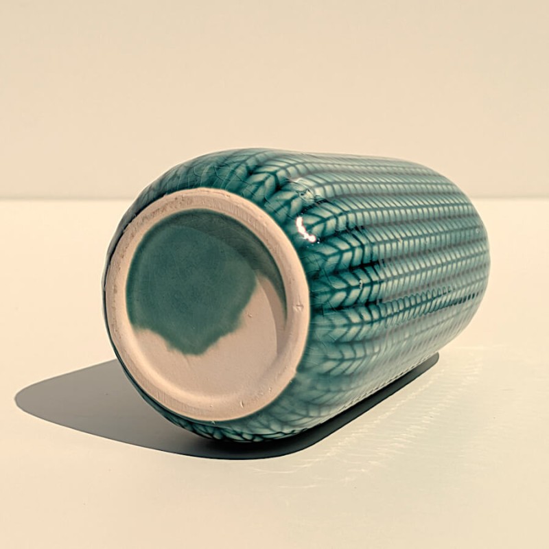 Vue de dessous : Base stable en faïence brute retournée du vase épi turquoise.