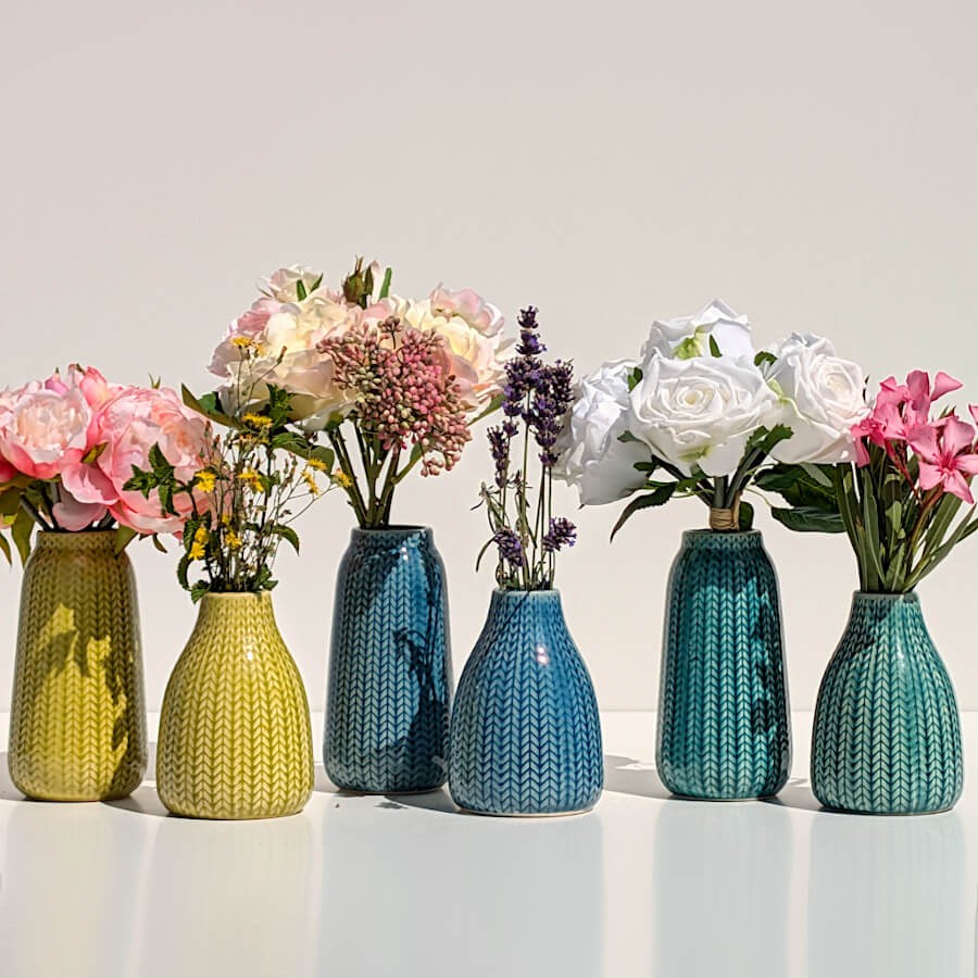 Alignement de vases épi fleuris montrant le contraste entre le jaune, le bleu et le turquoise.