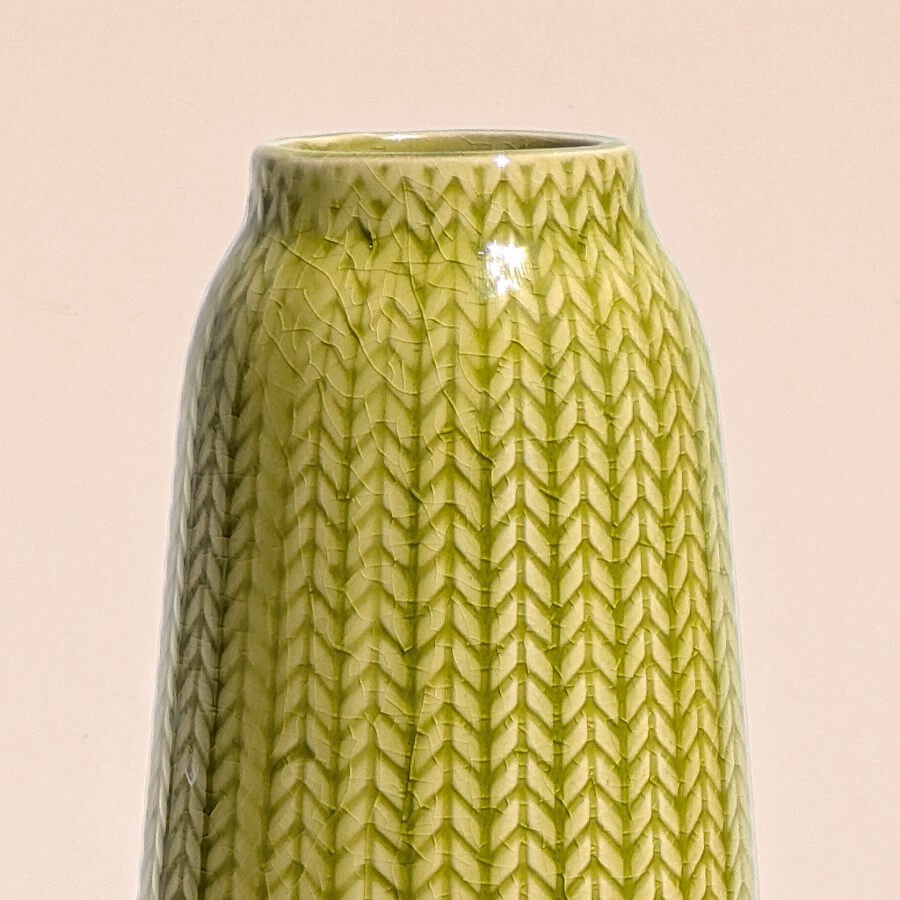 Gros plan col : Détail des finitions soignées sur le rebord supérieur du vase jaune.