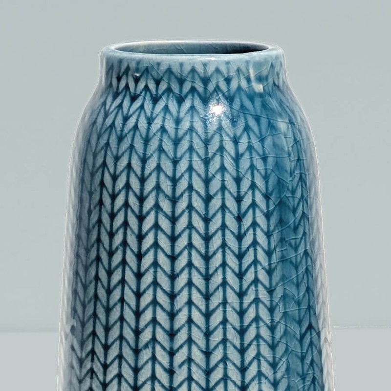 Gros plan col bleu : Zoom sur le col resserré et les motifs géométriques du vase bleu.