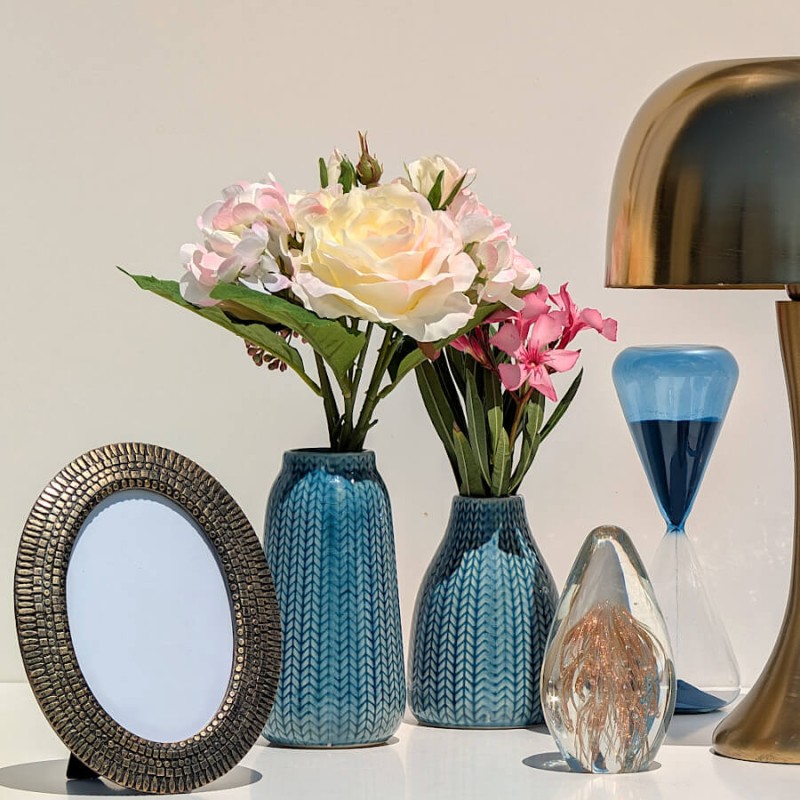 Composition marine : Vase bleu avec pivoines à côté d'un cadre rond et d'un sablier bleu de la collection Deco-Delight.