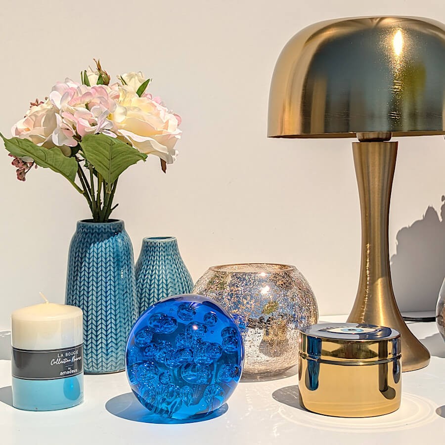 Focus table bleue : Soliflore bleu épi mis en scène avec une sphère en verre (sulfure) et une lampe champignon design.