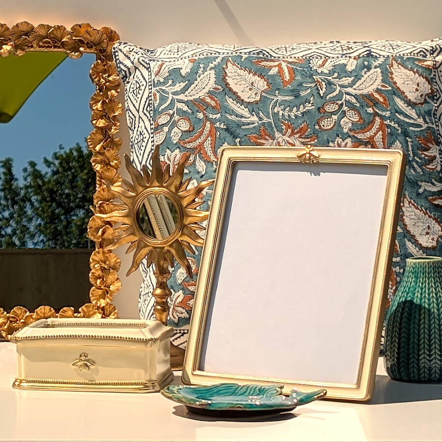 Cadre abeille dorée posé près de la boîte à bijoux assortie, du coussin bleu et de notre miroir Feuilles de Gingko.