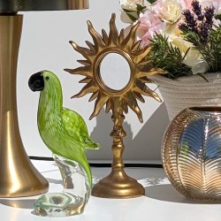 Ambiance Tropicool : Miroir sur pied soleil or associé à une figurine perroquet vert et une lampe champignon dorée.