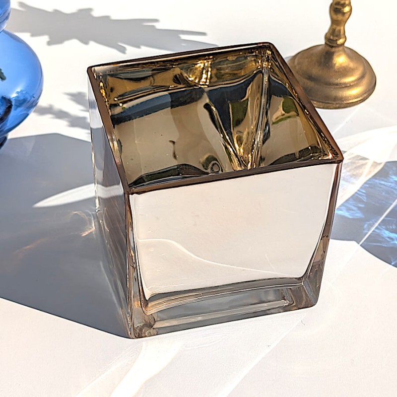 Vue rapprochée de la brillance miroitante et de la transparence du cube doré sous le soleil.