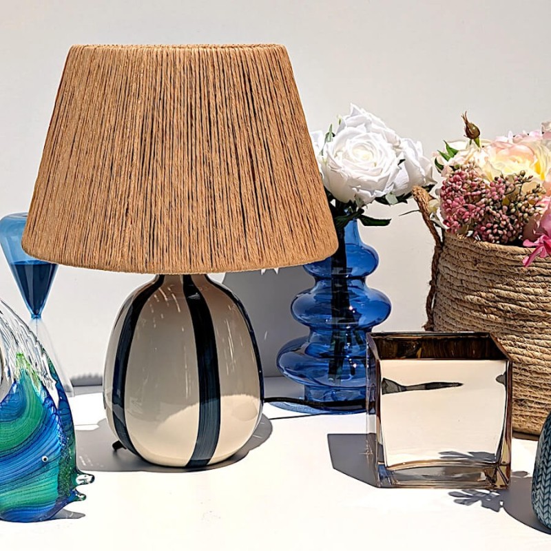 Décoration d'été sur terrasse avec la lampe au style naturel et le photophore doré.
