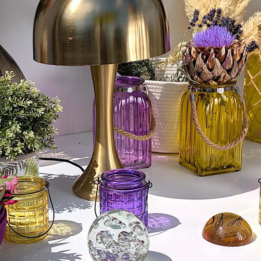 Scénographie de nuit : Ambiance cosy associant le vase violet à une lampe design rétro en laiton doré.